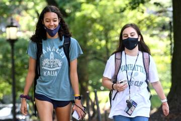 Two students walk side by side on campus