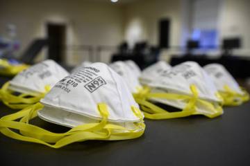 Close-up image of N95 masks with yellow straps stacked on a table